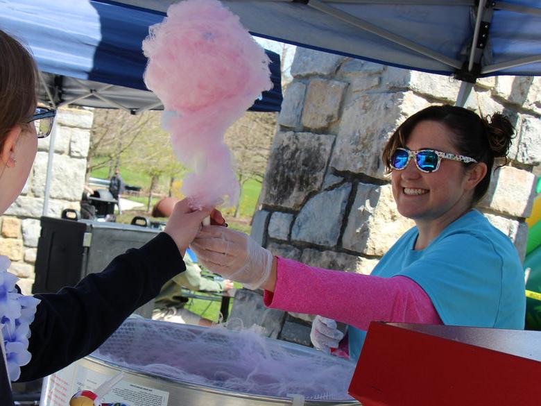 Autumn Fritz, Assistant Director, Community Development, Student Affairs handing out cotton candy during Spring Week